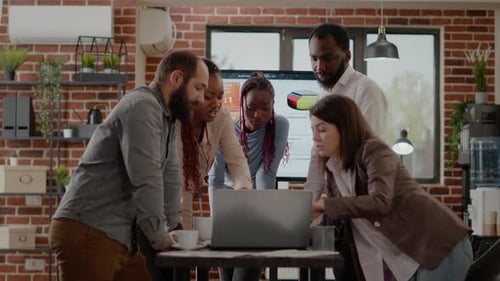 Team Collaborates on Laptop in Modern Office