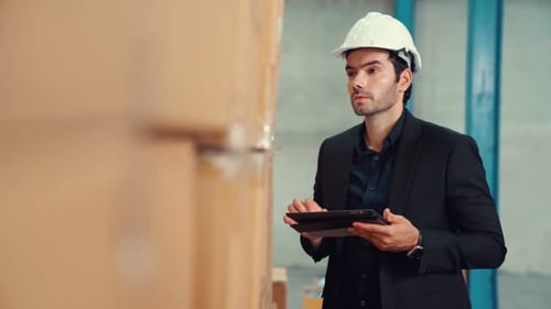 Factory Manager Using Tablet Computer in Warehouse or Factory