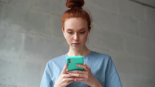 Woman With Red Hair Smiling Using Smartphone