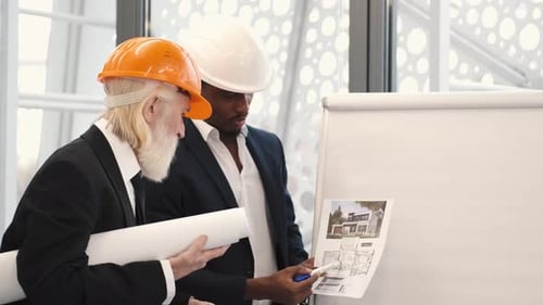 Architect and Engineer Looking at Scketch Blueprint at Office and Discussing Project