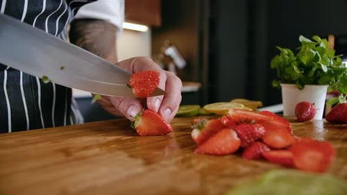 Close-up Man Chef Cuts Fresh Fruits Strawberry on Wooden Cutting Board Cooking