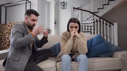 Couple Arguing on Couch in Bright Home Interior