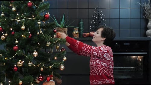 Woman Decorating Christmas Tree with Festive Ornaments