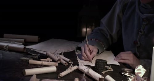 Writing on Parchment at Dark Desk with Quill