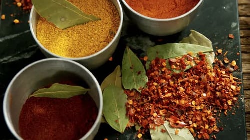 Colorful spices in metal bowls on rustic table