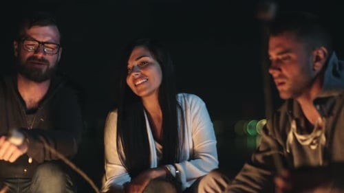 Friends Gather Around Campfire at Night
