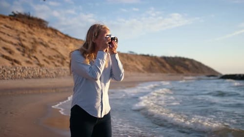 Photographer Using Slr Camera On Beach