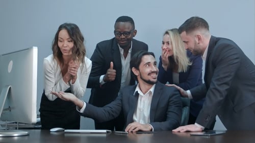 Excited Team Celebrates Success at Office Computer