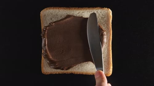 Spreading Chocolate Cream on a Slice of Bread