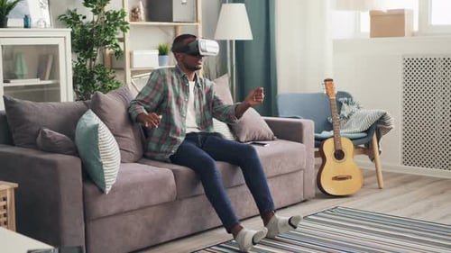Man Playing Video Game With VR Headset at Home