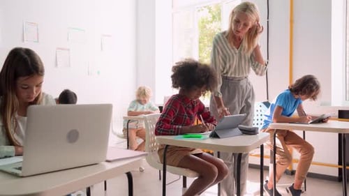 Teacher helping students in modern classroom
