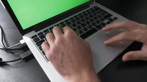 Person is using chroma key green screen laptop computer.