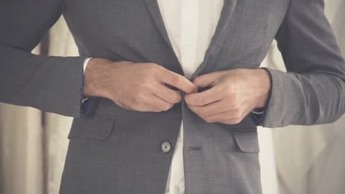 Man Buttoning His Grey Suit Jacket
