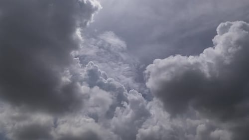 Zeitraffer von sich schnell bewegenden, wirbelnden Gewitterwolken am Nachmittag vor einem hinterleuchteten blauen Himmel