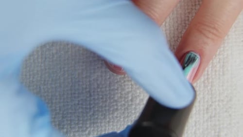 Young Woman Paints Her Nails with Natural Blue Gel Base. Nails Manicure.