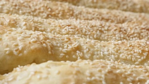 Filo pie with sesame cheese and spinach in tray 4K 2160p 30fps UHD footage - Close-up rows of rolle