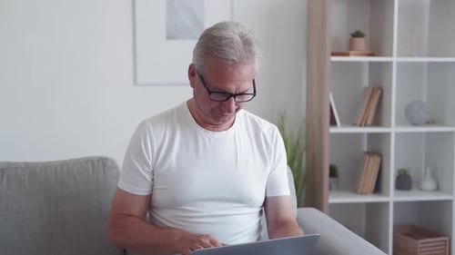 Surprised Man Using Laptop in Bright Home