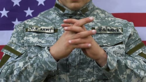 Soldier Clasped Hands in Front of American Flag