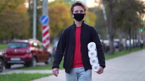 Young Adult Walking with Toilet Paper in City