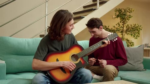 Man Plays Guitar and Sings with Friend