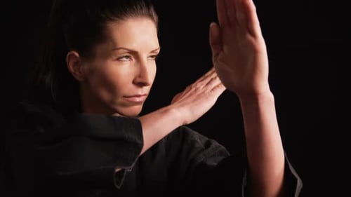 Woman Practicing Self Defense in Black Studio