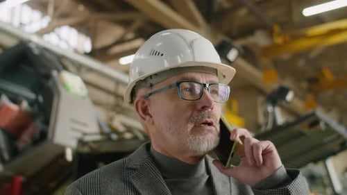 Mature Engineer Talking on Cell Phone in Factory