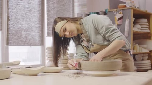 Woman Shaping Clay on Pottery Wheel in Studio
