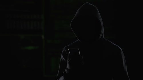 Dark Figure with Cellphone and Streaming Code