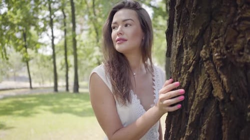 Beautiful Woman Posing by Tree in City Park