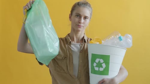 Retrato en cámara lenta de una mujer joven con bolsas de plástico reutilizables que apoyan el reciclaje