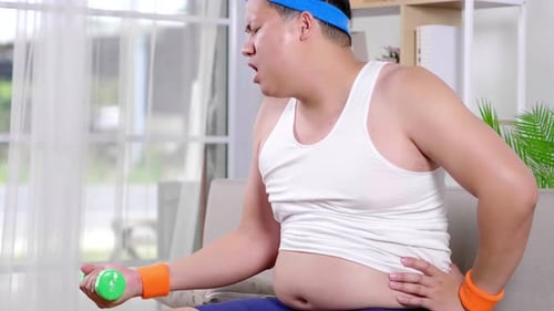 Man Lifts Dumbbell With Great Effort