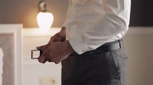 Groom Wears Belt Man in White Shirt Puts Belt on Pants in Wedding Morning Businessman Preparation
