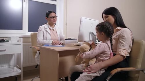 Doctor Consults with Mother and Child in Office