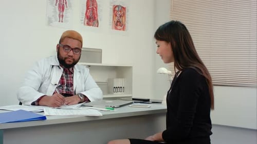 Doctor Consults with Female Patient in Office