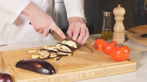 Nahaufnahme eines Küchenchefs, der meisterhaft buntes Gemüse auf einem Schneidebrett schneidet. Tomaten und Champignons