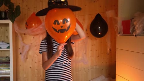 Child With Halloween Balloon Celebrates at Home