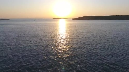 Fishing Boat Sailing at Sunset and Reflection of Evening Sun on the Sea