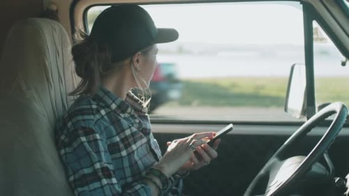 Woman Uses Cellphone Inside a Vehicle