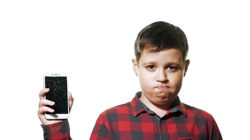 Boy Holds Broken Smartphone with Cracked Screen
