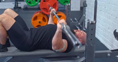 Man Doing a Bench Press Lying on a Bench in the Gym
