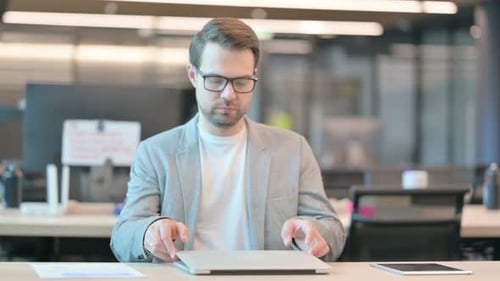 Man Coming in Office, Using Laptop