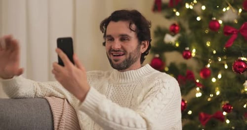 Man Connects with Family on Phone During Christmas