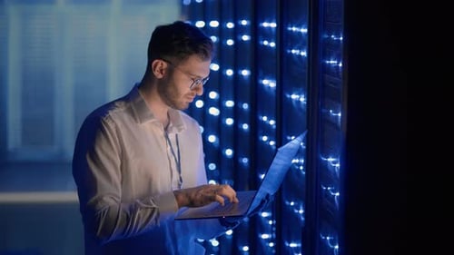 IT Technician in Data Center Digital Server Room Controlling Work of Rack Server Cabinets with a