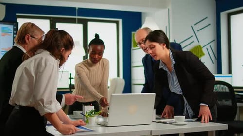 Team Collaborates on Laptop in Bright Office