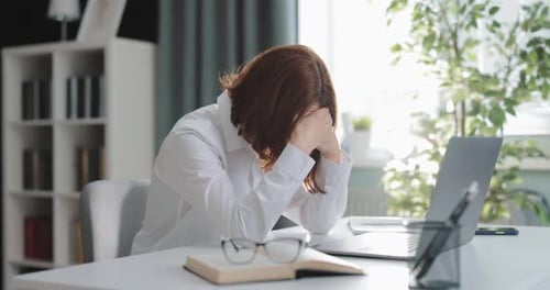 Adult with Head in Hands at Desk