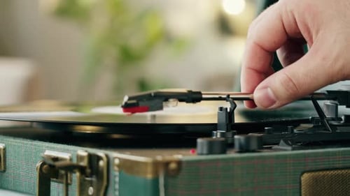 Hand Places Needle on a Vintage Turntable