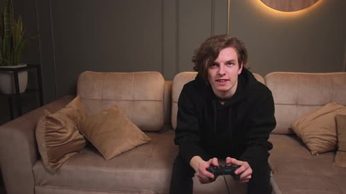 Young Adult Plays Video Games with Controller