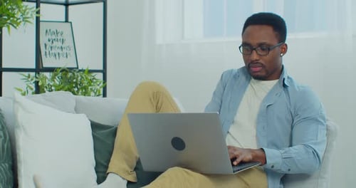 Young Man Relaxing at Home Using Laptop