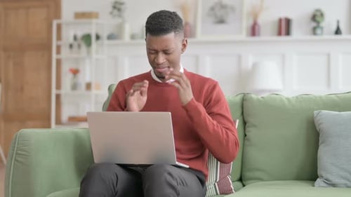 Young Adult Using Laptop Has Headache on Couch