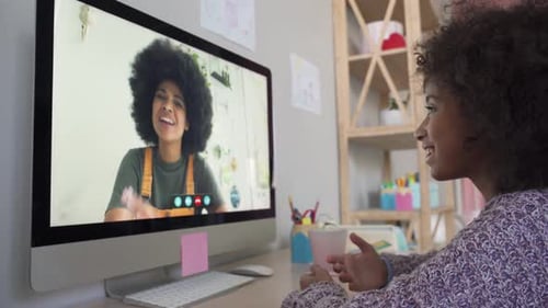 Girl Video Chats with Friend on Computer at Home